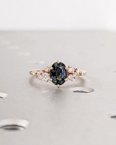 a blue and white diamond ring sitting on top of a table