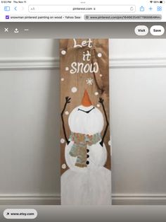 a wooden sign with a snowman painted on it's side and the words let it snow