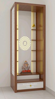 a wooden shelf with a buddha statue on top and lights in the bottom, next to a white wall