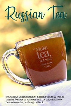 a cup of tea sitting on top of a white cloth covered table with the words russian tea