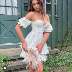 a woman in a white dress posing for the camera with her hands on her hips