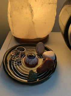 a table topped with a plate filled with different types of items next to a lamp