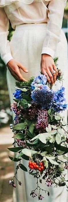 a woman holding a bouquet of flowers in her hands