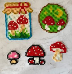 cross stitch mushroom coasters are displayed on a table