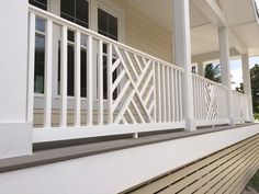 a white porch railing on a house with trees in the background