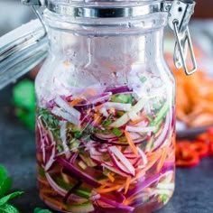 a jar filled with sliced vegetables on top of a table