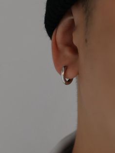 a close up of a person wearing a pair of earring's in front of a white background