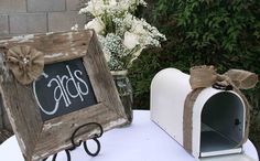 a white table topped with a mailbox and a chalkboard sign