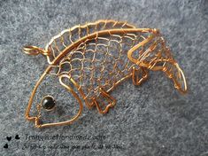 a gold fish brooch with a black bead on it's back end