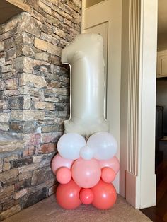 balloons are stacked on top of each other in front of a brick wall and door