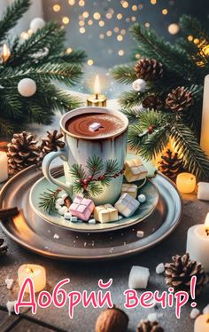 a cup of hot chocolate with marshmallows and pine cones on a saucer surrounded by candles