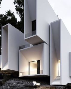 an unusual white building with stairs leading up to it's second floor and windows