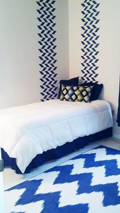 a bedroom with blue and white decor on the walls