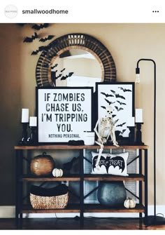 a shelf with halloween decorations on it in front of a mirror and a wall hanging