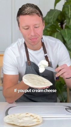 a man in an apron is eating some food on a plate and the caption reads if you put cream cheese on it