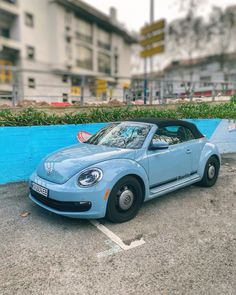 a small blue car parked in a parking lot