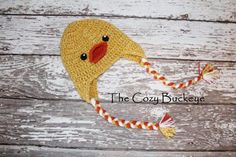 a crocheted hat with a yellow ducky on the front and red nose