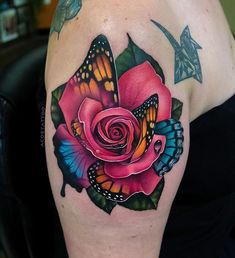 a rose with butterflies around it on the arm and shoulder, is shown in color