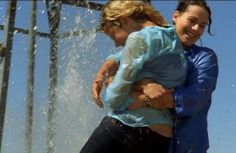 two women are playing in the water with their arms around each other as they laugh