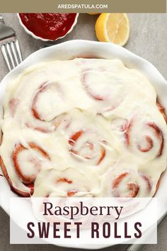 raspberry sweet rolls in a white dish with text overlay that reads, raspberry sweet rolls