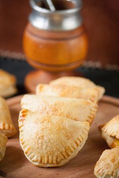 several small pastries sitting on top of a wooden plate