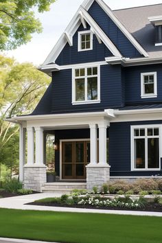 a large blue house with white trim and two story windows on the second floor is shown