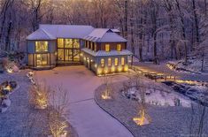 an aerial view of a house in the woods at night with lights on it's windows