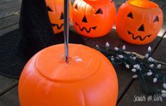 three orange pumpkins sitting on top of a wooden table next to a candle holder