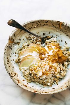 a bowl filled with oatmeal and apples on top of a marble counter