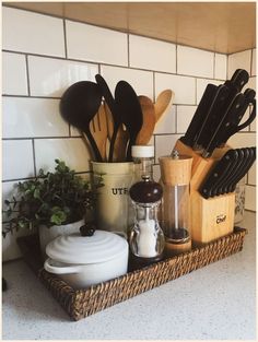 kitchen utensils and cooking utensils are arranged in a basket on the counter