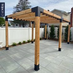 a wooden pergola sitting on top of a stone patio