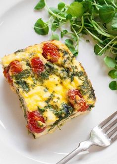 a piece of quiche on a white plate with a fork next to the dish