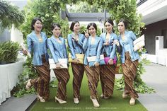 four women in matching outfits posing for the camera