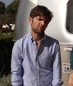 two people standing in front of a trailer