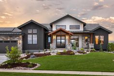 a large house with lots of windows on the front and side of it, surrounded by grass