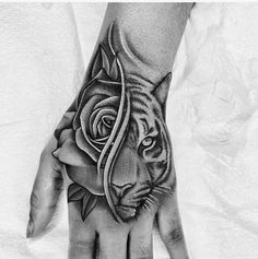 a hand with a tiger and rose tattoo on it