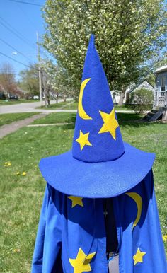 a blue wizard's hat with yellow stars on it is sitting in the grass