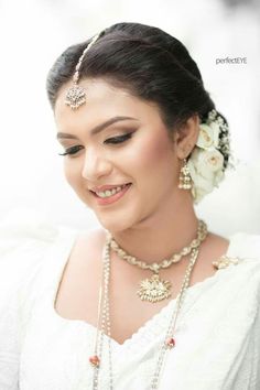 a woman wearing a necklace and earrings with flowers in her hair