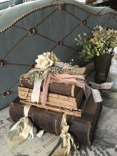 several old books stacked on top of each other with ribbons tied around them and flowers