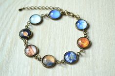 Handmade solar system bracelet,with 8 planets of the solar system  Mercury, Venus, Earth, Mars, Jupiter, Saturn, Uranus, Neptune There are two colors of metal - Brass & Silver Bracelet length is 19cm + 4 cm. The size of each picture pendant is 12mm.It is covered by a clear cabochon resin.Then it will show a cute 3D effect.The bracelet length is 16cm + 4cm. If you need it to be longer or shorter,please just leave me a note when make order or sent me a convo. All the material is all nickel free. Item will come with nice gift box packing(in random color) Please notice the material is not waterproof,please take off it before bath or swim. For more amazing items,please click here https://www.etsy.com/shop/hmpisces Customize order is available. The picture could be made into necklace,ring,earrin Planet Bracelet, Galaxy Bracelet, Bracelet Picture, Solar System Bracelet, 8 Planets, Bracelet Photo, Space Jewelry, Picture Pendant, The Solar System