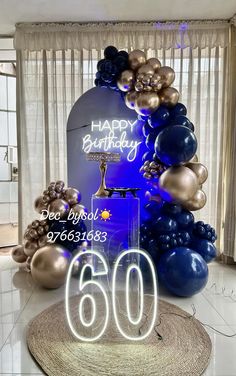 the birthday cake is surrounded by balloons and streamers in blue, gold and silver