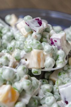 a spoon full of white and green candy with marshmallows on it's side