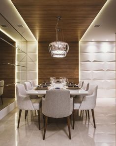 a dining room table with chairs and a chandelier hanging from the ceiling