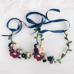 two flower headbands with blue ribbon on white background