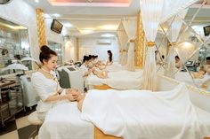 a woman getting her nails done at a nail salon with other women in the background