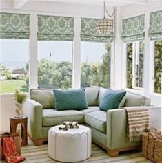 a living room filled with furniture and windows covered in green shades on top of them