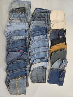 several pairs of jeans stacked on top of each other