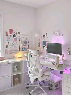 a white desk with a computer on top of it in a room filled with drawers