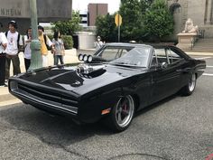 a black muscle car parked on the street