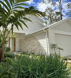 a white house surrounded by trees and plants